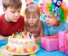 Девушка в момент выдува свечи на день рождения торт
